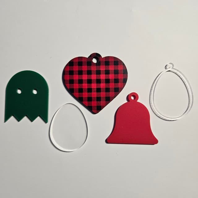 Various shapes cut from frosted acrylic, red and green dual finish acrylic, and plaid pattern plywood