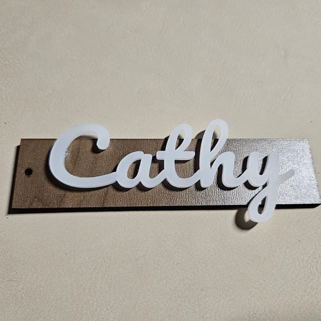 Elegant stocking tag with Cathy text in white semi-translucent acrylic and walnut plywood