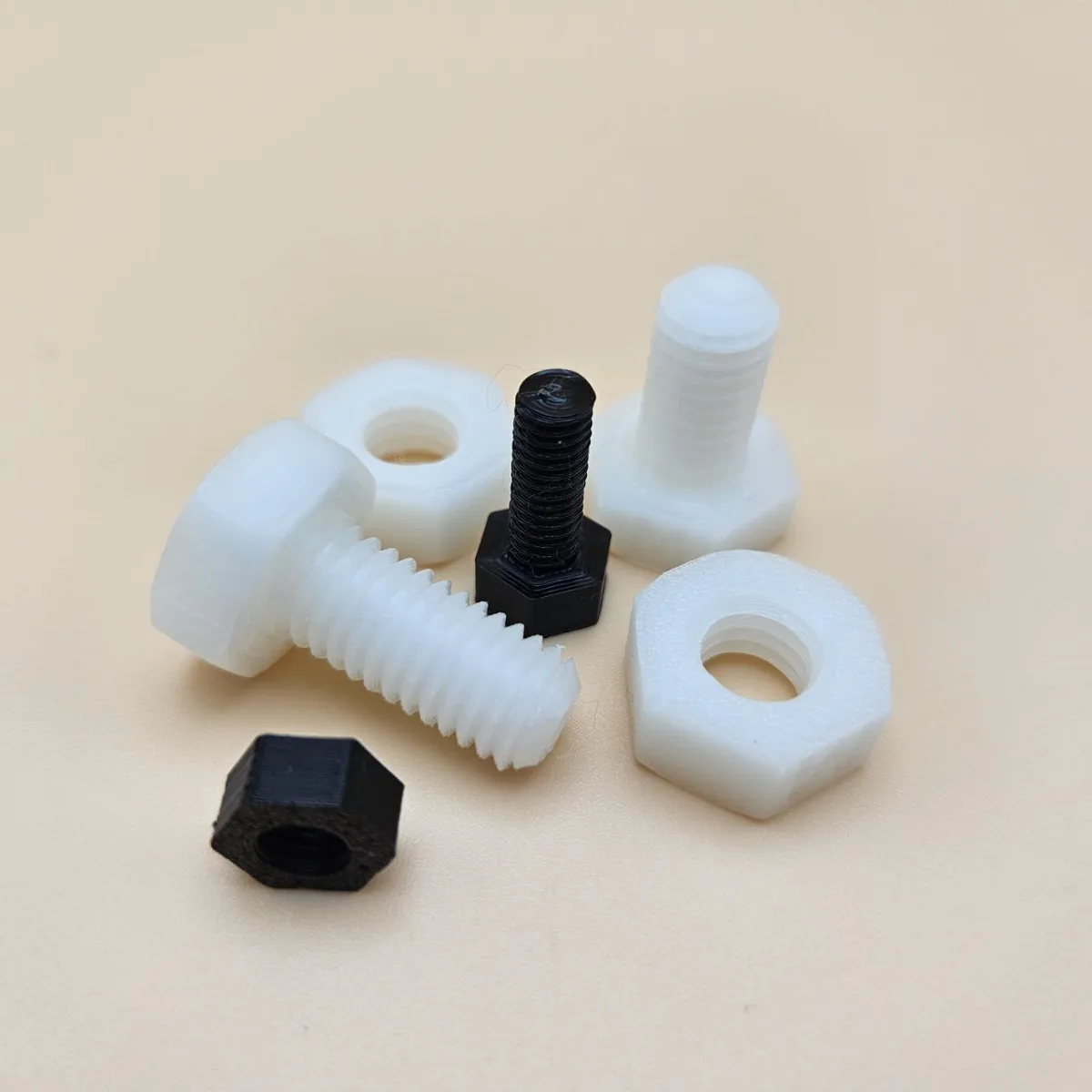 3D printed bolts and nuts in black and white PLA