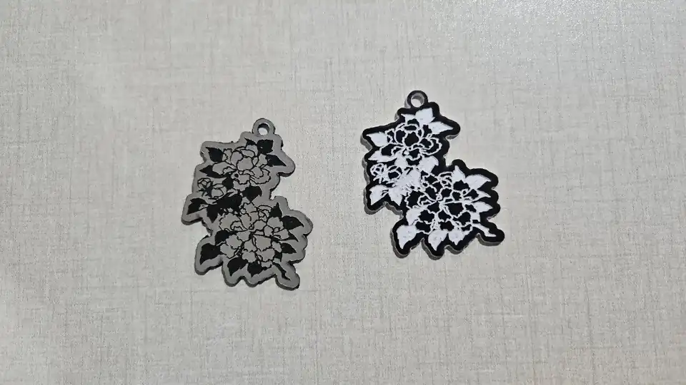 Dos llaveros de peonías grabados en acrílico bicolor, uno plata mate grabado en negro y otro marrón oscuro grabado en blanco
