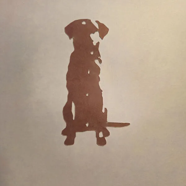 Sitting dog silhouette laser-cut from brown cardstock