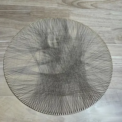 Laser-scored string art portrait on a round maple plywood disc