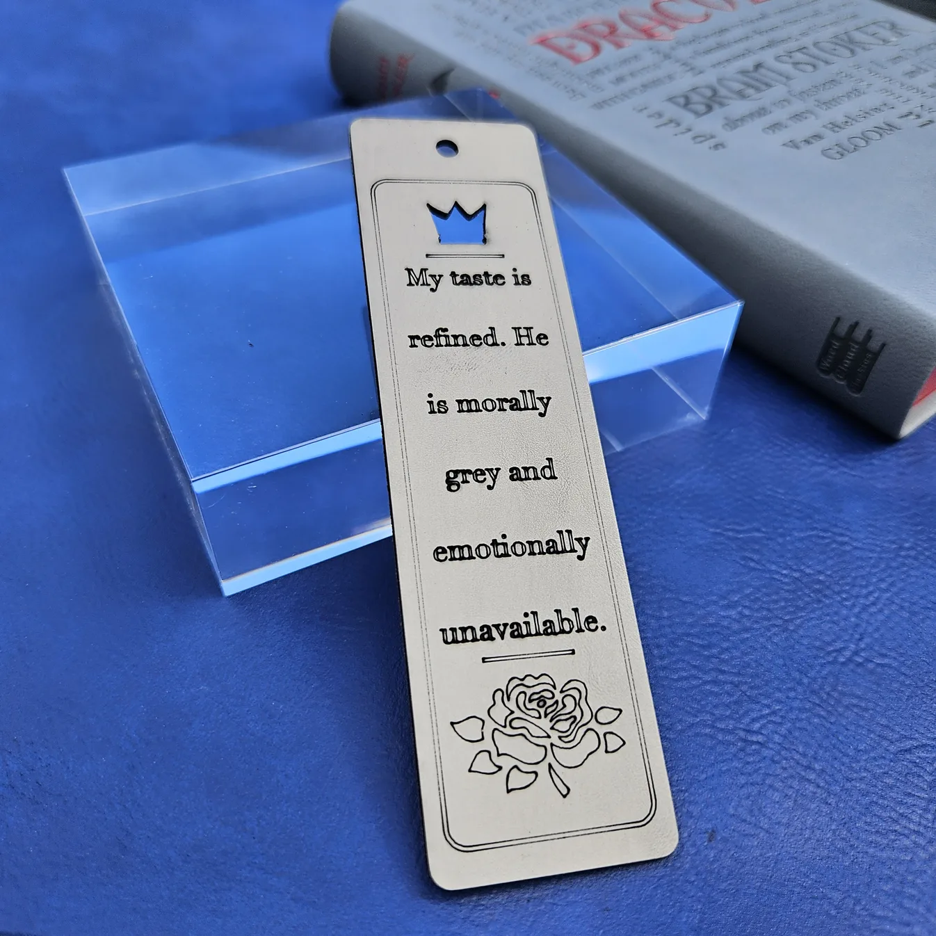 Engraved wooden bookmark reading "My taste is refined, he is morally grey and emotionally unavailable," with a crown cut-out and engraved rose, made by Sofia Reyker with MyLaserTools.