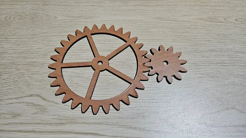 Laser cut spoked wheel and matching pinion in cherry plywood with crisp involute teeth